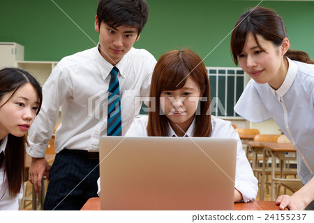 Female teacher surrounding students dealing with laptops and students frontal 24155237
