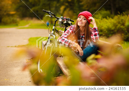 girl relaxing in autumnal park with bicycle. 24161535