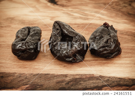 dried plums prunes on wooden table dried plums prunes on wooden table 24161551