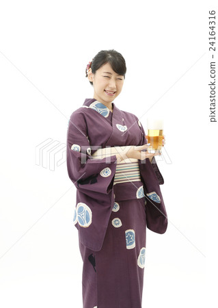 A woman in a yukata with a beer 24164316