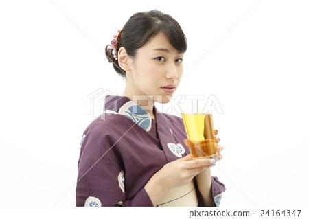 A woman in a yukata with a beer 24164347