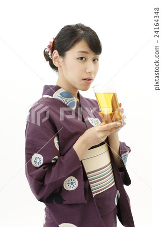 A woman in a yukata with a beer 24164348