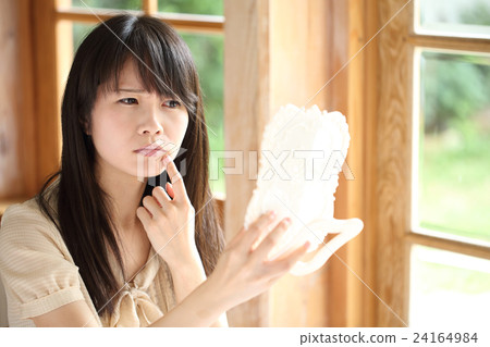 Young woman looking at a mirror 24164984