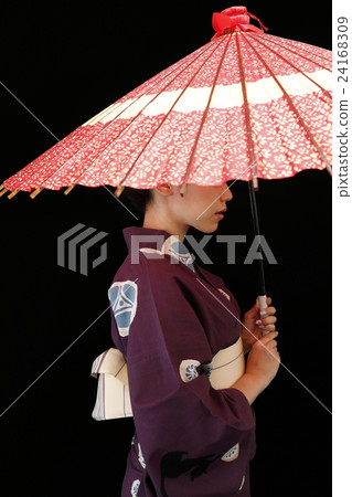A woman in a yukata standing on an umbrella 24168309