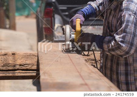 carpenter use electric saw to sawing wood 24174559