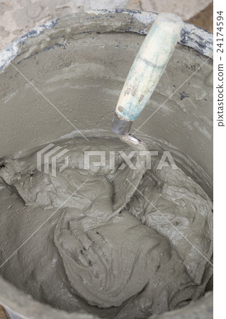 trowel and bucket with mortar at construction site 24174594