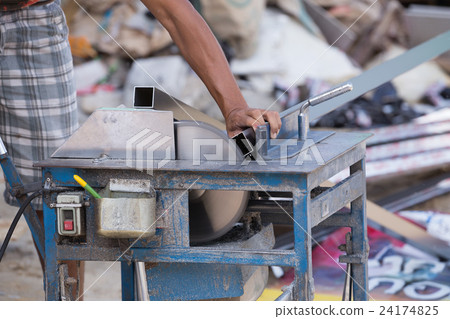Worker cutting aluminium with grinder blade 24174825