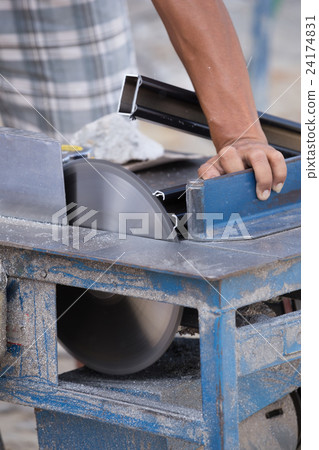 Worker cutting aluminium with grinder blade 24174831