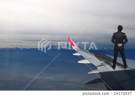 businessman standing on airplane wing which can see snow mountain, Challenge business concept businessman standing on airplane wing which can see snow mountain, Challenge business concept 24178837