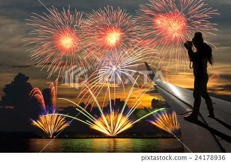 silhouette of photographer taking photo on airplane wing which can see Fantastic festive colorful fireworks, Challenge and success business concept 24178936