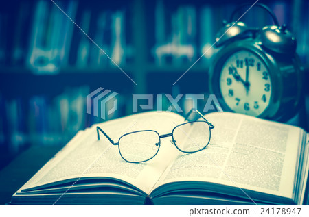 glasses on the book with clock in library, Education concept glasses on the book with clock in library, Education concept 24178947
