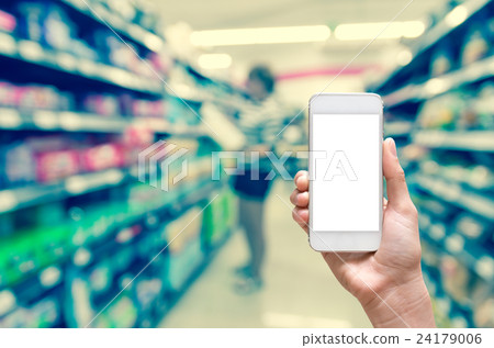 Female hand holding mobile smart phone touch screen on Abstract blurred photo of store with trolley in department store bokeh background Female hand holding mobile smart phone touch screen on Abstract blurred photo of store with trolley in department store bokeh background 24179006