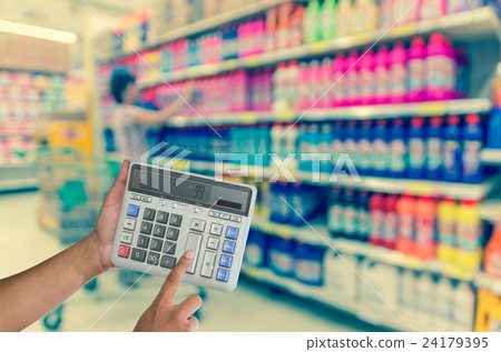 Hand touching buttons of calculator on the Abstract blurred photo of store in department store bokeh background 24179395