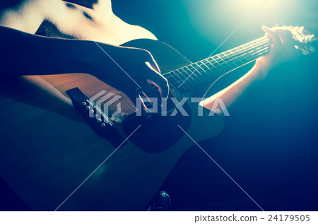 Closeup musician playing the guitar on spot light background, musical concept Closeup musician playing the guitar on spot light background, musical concept 24179505