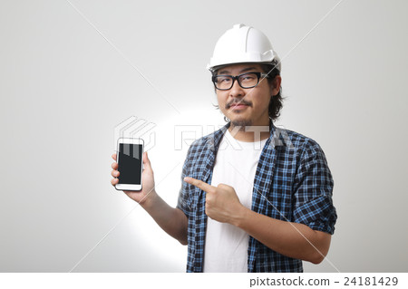 The Asian engineer points at mobile phone. The Asian engineer points at mobile phone. 24181429
