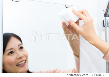Woman who brushes mirror with sponge cleaning melamine resin sponge Woman who brushes mirror with sponge cleaning melamine resin sponge 24188120