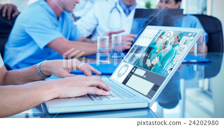 Composite image of doctor typing on keyboard with her team behin 24202980