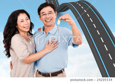Composite image of smiling couple holding a set of keys 24205534