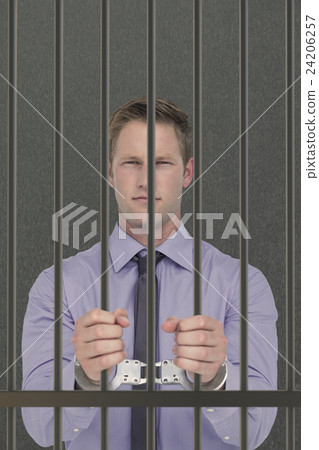 Composite image of handsome businessman wearing handcuffs Composite image of handsome businessman wearing handcuffs 24206257