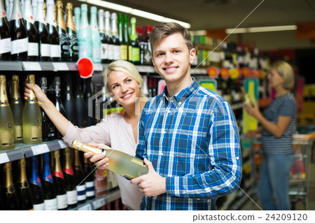 Family choosing wine at food shop 24209120