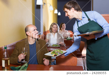 waiter serving senior male customer in cafe waiter serving senior male customer in cafe 24209355