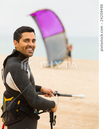 Smiling guy with kiteboardon at the beach Smiling guy with kiteboardon at the beach 24209498