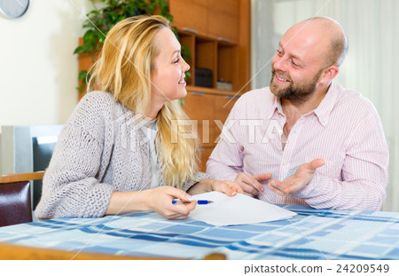 Couple reading insurance contract Couple reading insurance contract 24209549