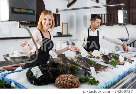 Sellers working in fish store. Sellers working in fish store. 24209727