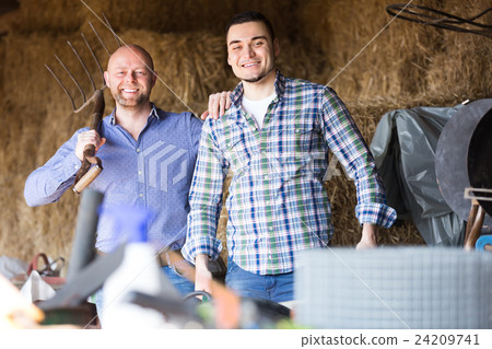 Two farmers working in barn 24209741