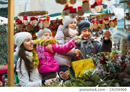 Happy cheerful family of four buying Caga Tio Happy cheerful family of four buying Caga Tio 24209906