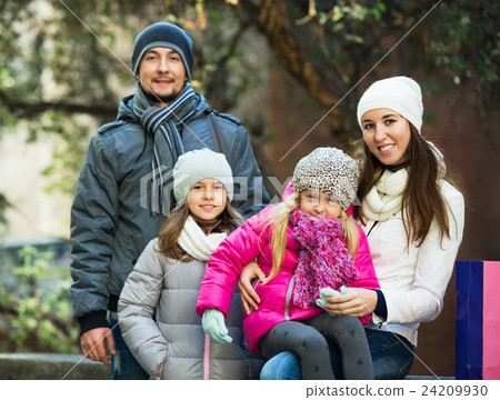Winter portrait of cheerful smiling adults with daughters . Focus on woman and ittle girl Winter portrait of cheerful smiling adults with daughters . Focus on woman and ittle girl 24209930