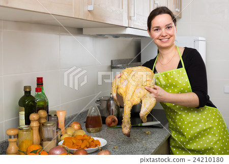 Woman preparing capon indoors . Woman preparing capon indoors . 24210180