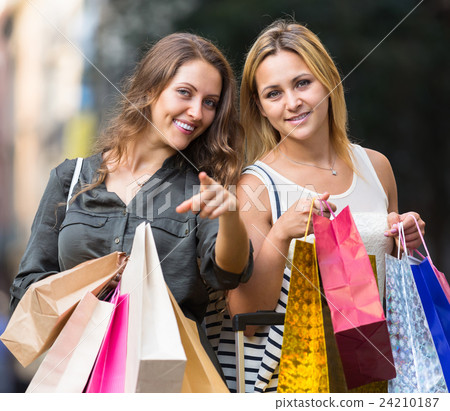 Two young women holding shopping bags. Two young women holding shopping bags. 24210187