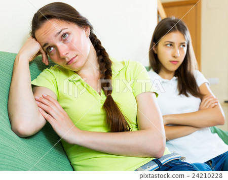 Woman friends sitting and discontent Woman friends sitting and discontent 24210228