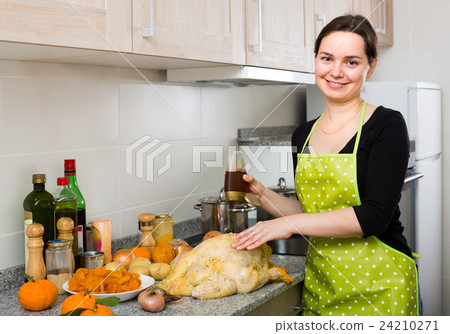 Woman preparing capon indoors . Woman preparing capon indoors . 24210271
