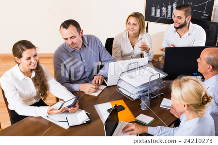 colleagues discussing price development at office colleagues discussing price development at office 24210273