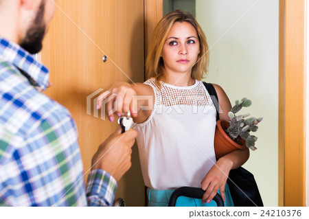 Frustrated couple standing at doorway 24210376
