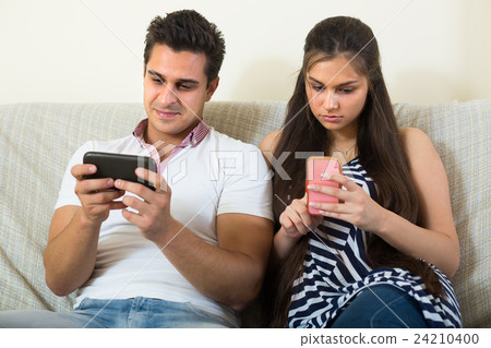 Couple networking with cell phones . 24210400