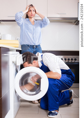 Repairman and woman near washing machine. Repairman and woman near washing machine. 24210584