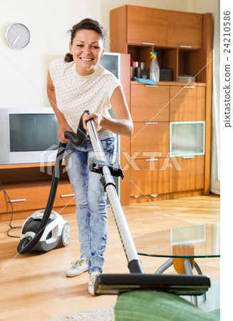 woman hoovering apartment 24210586