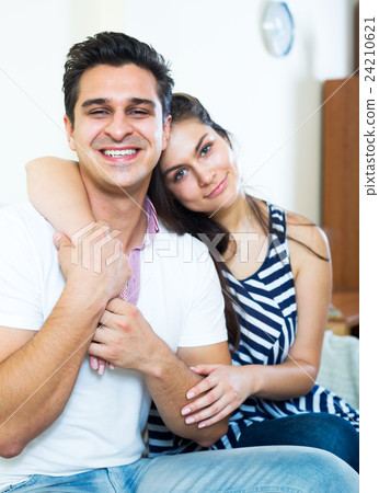 Smiling young spouses posing and hugging Smiling young spouses posing and hugging 24210621