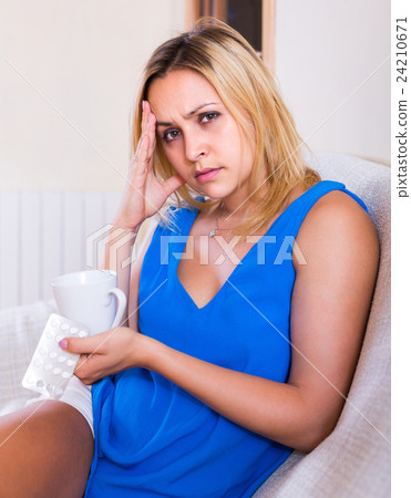 Young woman with pills at home 24210671