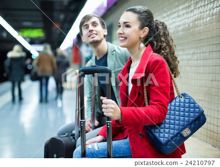 Young passengers with luggage waiting for train Young passengers with luggage waiting for train 24210797