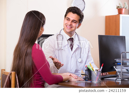 Patient and therapeutist at desk in clinic. 24211159