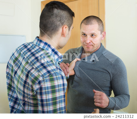 Two adult males fighting indoor 24211312