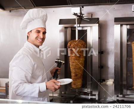 Adult arabian cook posing near meat for kebab 24211706