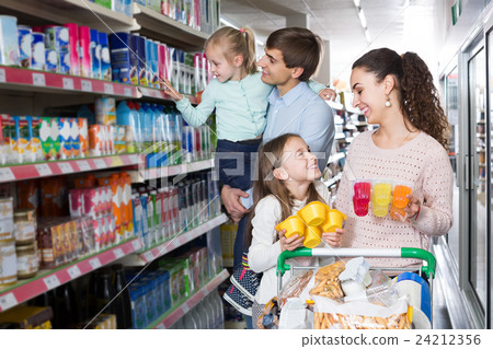 customers with children selecting sweet dairy products in hypermarket customers with children selecting sweet dairy products in hypermarket 24212356