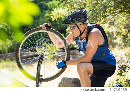 Senior man is touching his bike Senior man is touching his bike 24216489