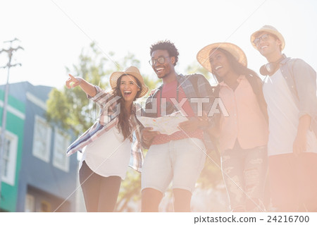 Friends holding map and pointing 24216700