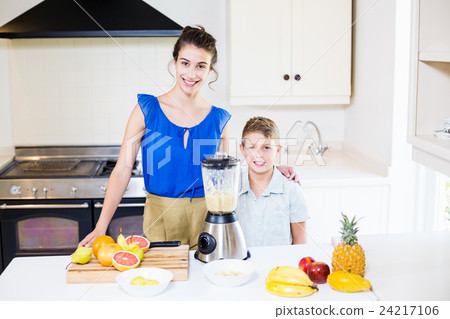 Mother and son standing at table in kitchen Mother and son standing at table in kitchen 24217106